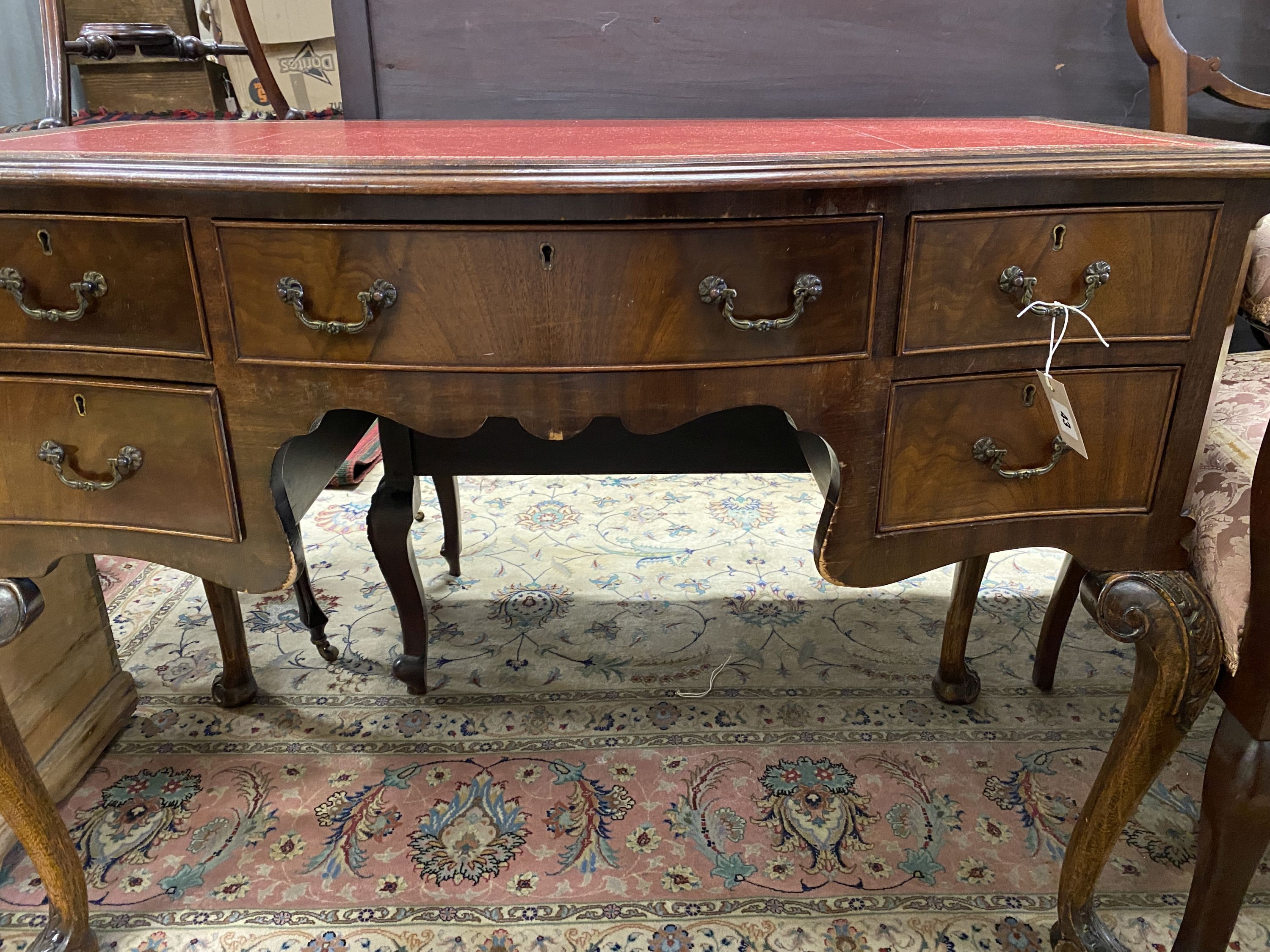 A reproduction George III style serpentine mahogany kneehole writing table, width 107cm, depth 55cm, height 78cm